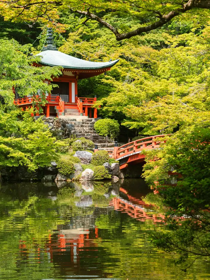 A vermilion pagoda and arched bridge among maples at Daigo-ji, Kyoto, Japan