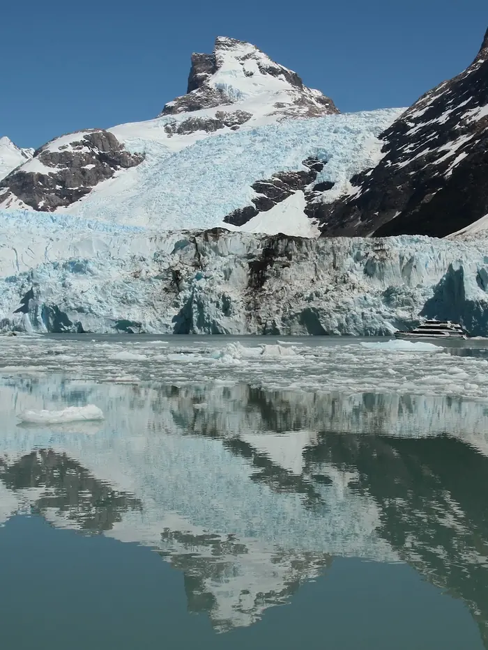 The Spegazzini glacier meeting still water below a snow-capped peak, Patagonia